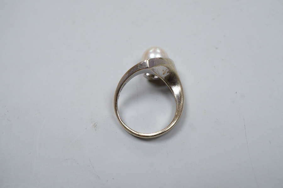 A cultured pearl ring, set with a cultured pearl, to an asymmetrical curved mount in white gold, size J1/2, stamped K14WG, maker's mark, gross weight 6 grams, Condition: Overall good - wear to rhodium, glue residue to ba